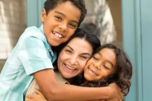 Mother hugging happy kids after successful new treatment for migraine